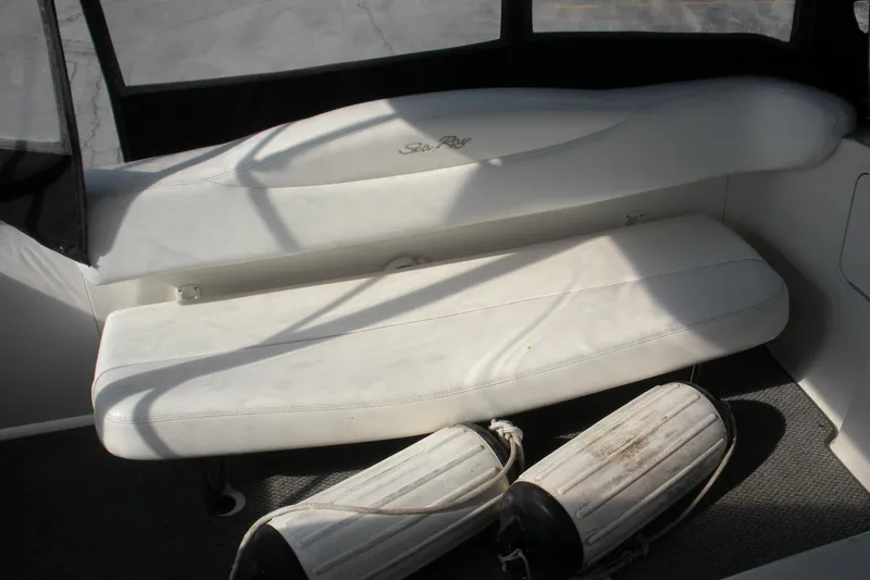 Slide: The Image of 2005 Sea Ray 280 Sundancer interior with white seating and boat fenders. - 17