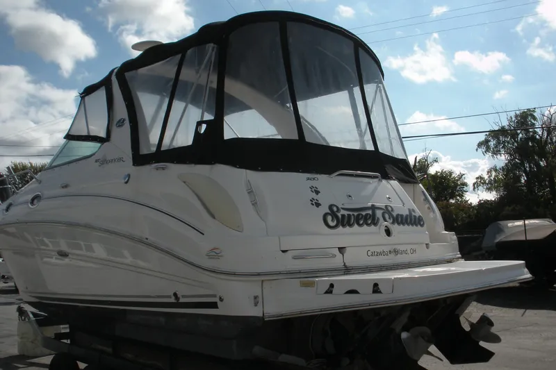 Slide: The Image of 2005 Sea Ray 280 Sundancer boat with black canopy, docked outdoors. - 18