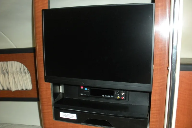 Slide: The Image of Flat-screen TV in 2005 Sea Ray 280 Sundancer cabin, wooden paneling, and media controls. - 6