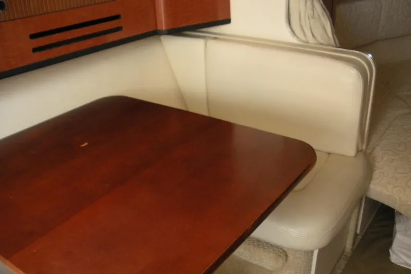 Slide: The Image of 2005 Sea Ray 280 Sundancer interior with wooden table and cream seating. - 8