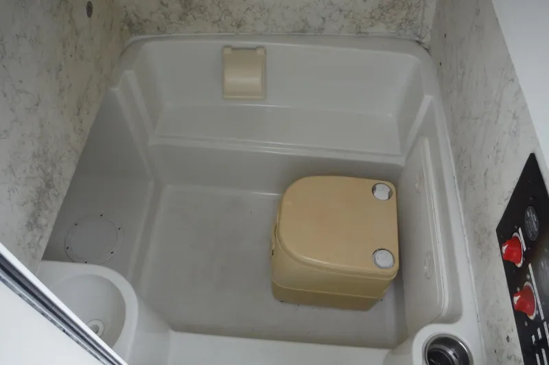 Slide: The Image of 2008 Sailfish 2660 CC boat interior with compact bathroom and beige portable toilet. - 16