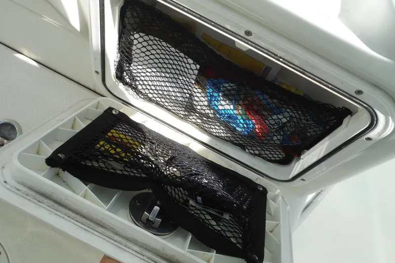 Slide: The Image of Storage compartment on a 2008 Sailfish 2660 CC boat with netting and supplies. - 24