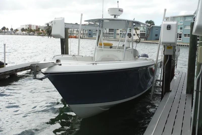 Slide: The Image of 2008 Sailfish 2660 CC boat docked at marina with modern buildings in background. - 3