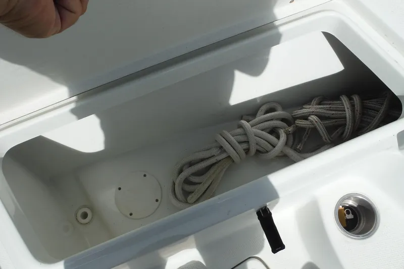 Slide: The Image of Storage compartment with coiled rope on a 2008 Sailfish 2660 CC boat. - 32