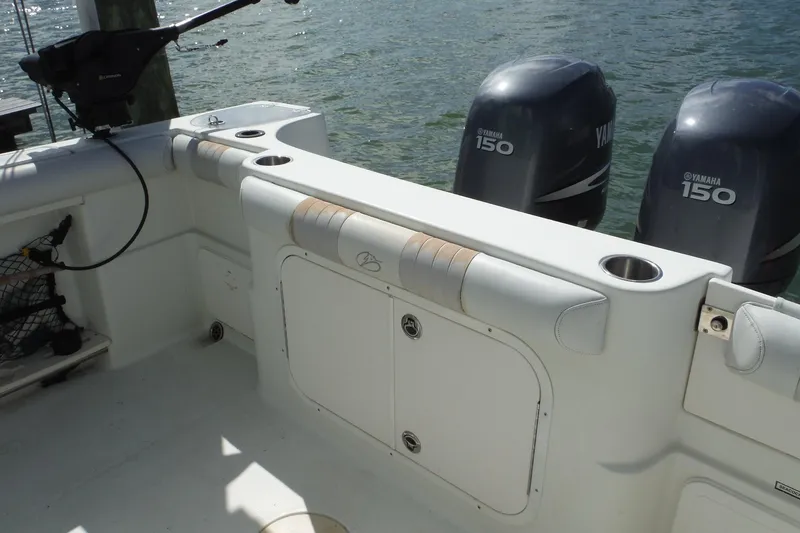 Slide: The Image of 2008 Sailfish 2660 CC boat interior with Yamaha 150 engines, featuring fishing rod holders. - 38