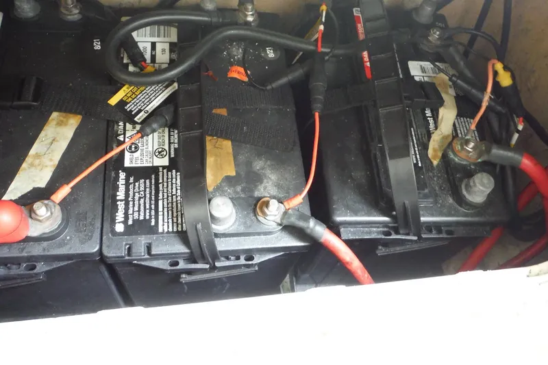 Slide: The Image of Batteries in a 2008 Sailfish 2660 CC boat, featuring West Marine labels and red cables. - 41