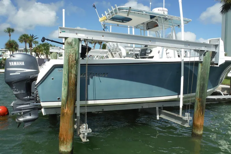 Slide: The Image of 2008 Sailfish 2660 CC boat with Yamaha engine on a lift, docked by palm trees. - 45