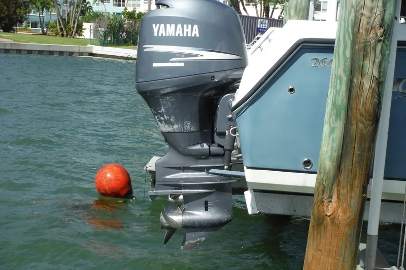 Slide: The Image of 2008 Sailfish 2660 CC boat with Yamaha outboard motor docked near a buoy. - 46