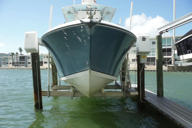 Slide: The Image of 2008 Sailfish 2660 CC boat on lift, docked near waterfront buildings. - 51