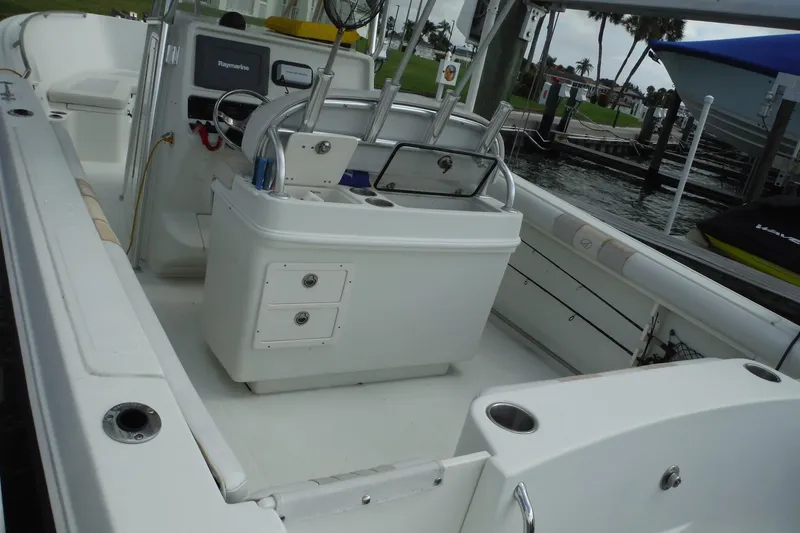 Slide: The Image of 2008 Sailfish 2660 CC boat interior with console and seating, docked by the water. - 6
