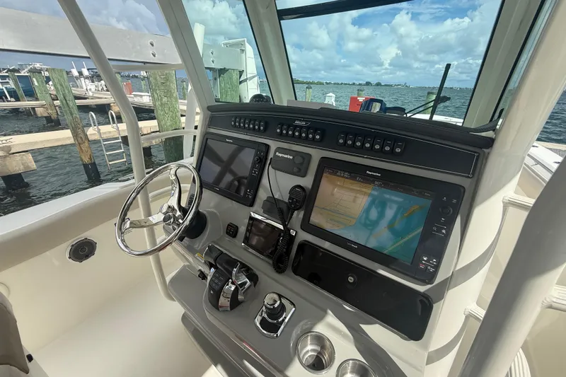 Slide: The Image of Helm of 2016 Boston Whaler 330 Outrage with navigation screens and steering wheel. - 14