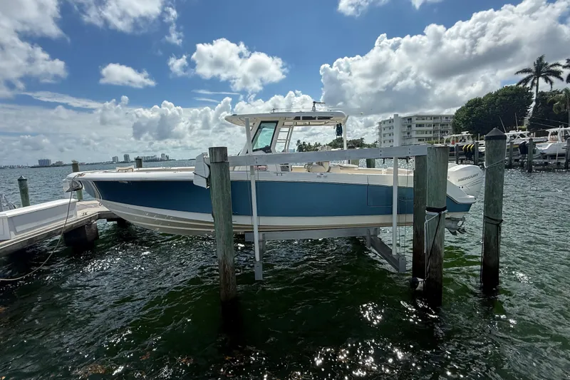 Slide: The Image of 2016 Boston Whaler 330 Outrage boat docked on a sunny day. - 2