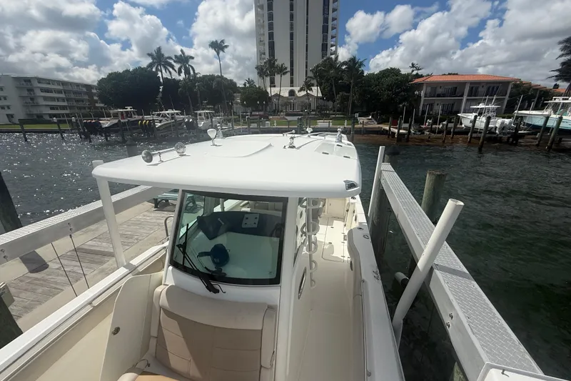 Slide: The Image of 2016 Boston Whaler 330 Outrage docked at marina, surrounded by waterfront buildings. - 24