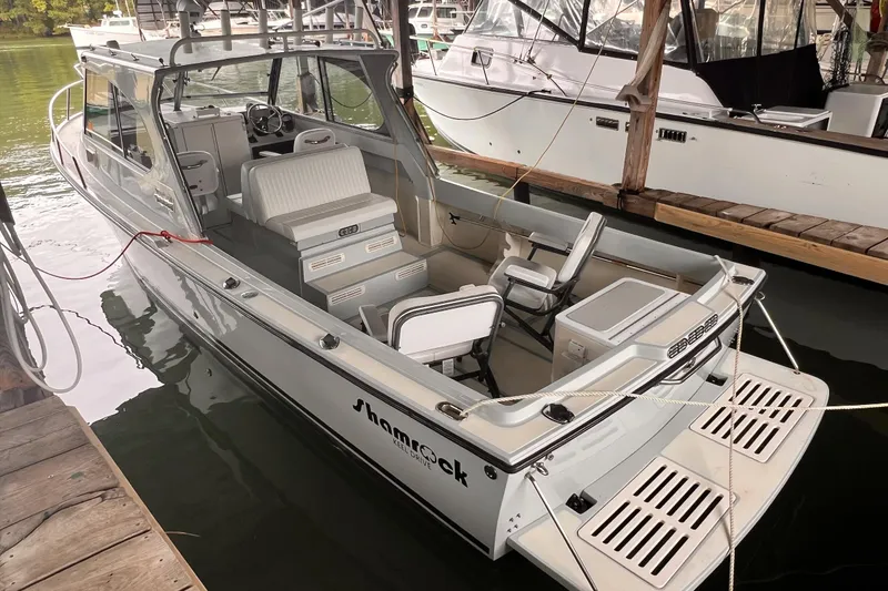 The Image of 1989 Shamrock 260 Hardtop boat docked, featuring spacious seating and classic design. - 0