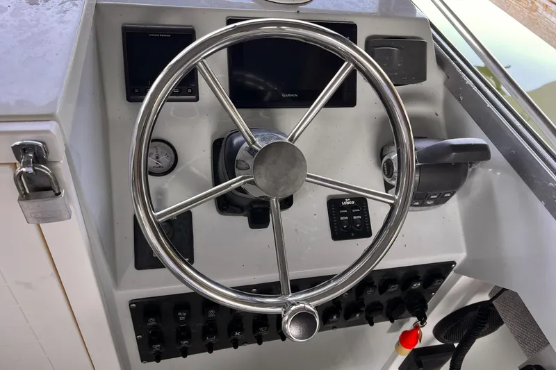 Slide: The Image of 1989 Shamrock 260 Hardtop boat dashboard with steering wheel and control panel. - 12