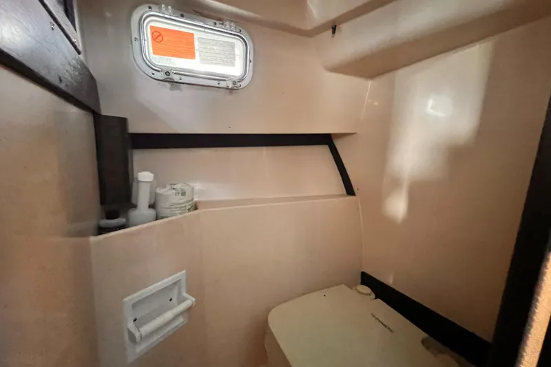 Slide: The Image of 1989 Shamrock 260 Hardtop boat interior with window and storage area. - 24