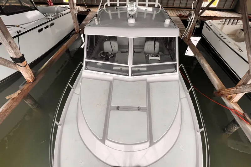 Slide: The Image of 1989 Shamrock 260 Hardtop boat docked in a covered marina, top view. - 3