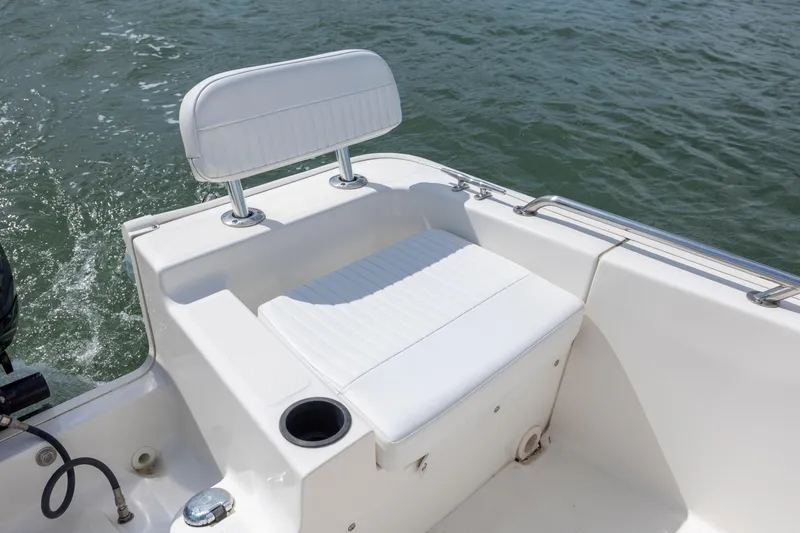 Slide: The Image of 2018 Boston Whaler 210 Montauk boat seat with white upholstery on water. - 14