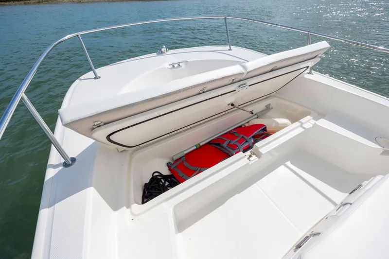 Slide: The Image of 2018 Boston Whaler 210 Montauk boat with open storage compartment, life jacket visible. - 20