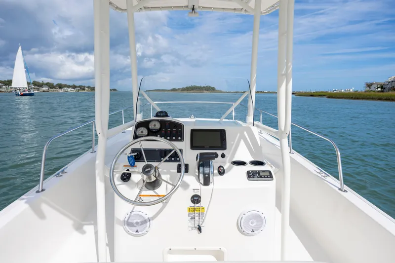 Slide: The Image of 2018 Boston Whaler 210 Montauk boat dashboard on a sunny day, with scenic water view. - 26