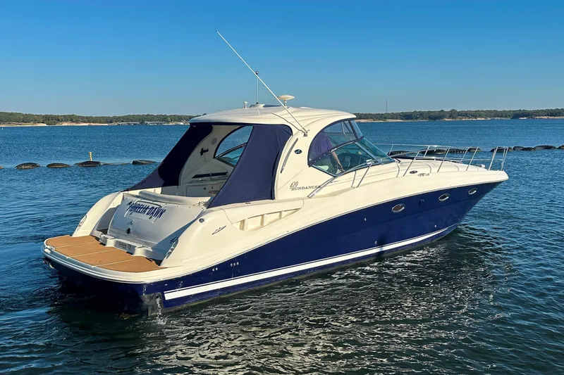 Slide: The Image of 2004 Sea Ray 420 Sundancer yacht on calm water, featuring sleek design and blue hull. - 11