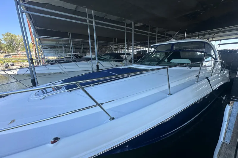 Slide: The Image of 2004 Sea Ray 420 Sundancer yacht docked in a marina under a covered shelter. - 27