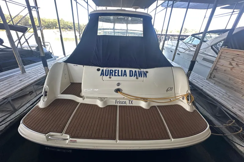 Slide: The Image of 2004 Sea Ray 420 Sundancer docked, rear view with cover, named "Aurelia Dawn". - 33