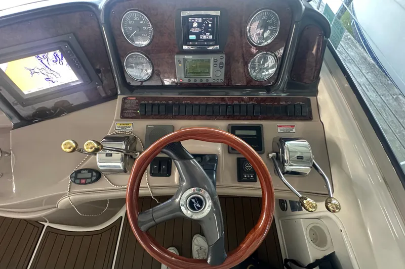 Slide: The Image of 2004 Sea Ray 420 Sundancer helm with wood steering wheel and navigation instruments. - 48