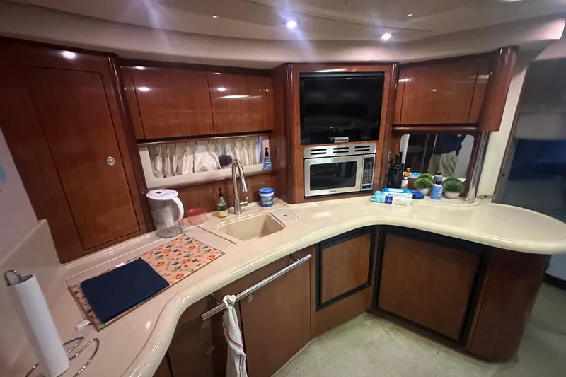 Slide: The Image of Luxurious 2004 Sea Ray 420 Sundancer yacht kitchen with modern amenities and elegant wood cabinetry. - 52
