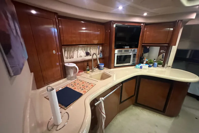 Slide: The Image of Luxurious 2004 Sea Ray 420 Sundancer yacht kitchen with modern amenities and elegant wood cabinetry. - 59