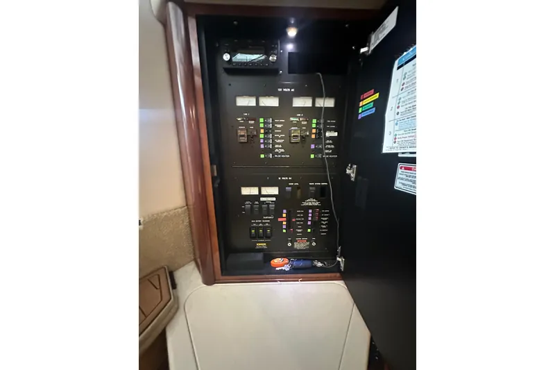 Slide: The Image of Electrical panel inside 2004 Sea Ray 420 Sundancer yacht, showcasing circuit breakers and controls. - 68