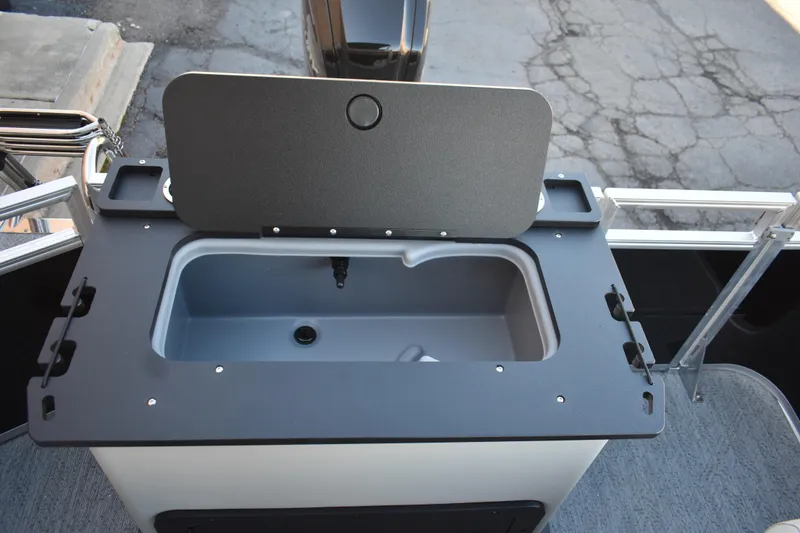 Slide: The Image of 2026 Sun Tracker Fishin' Barge 22 DLX livewell with open lid, showcasing interior features. - 10