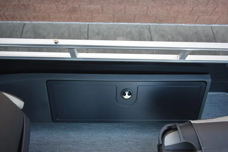 Slide: The Image of 2026 Sun Tracker Fishin' Barge 22 DLX storage compartment with secure latch. - 13