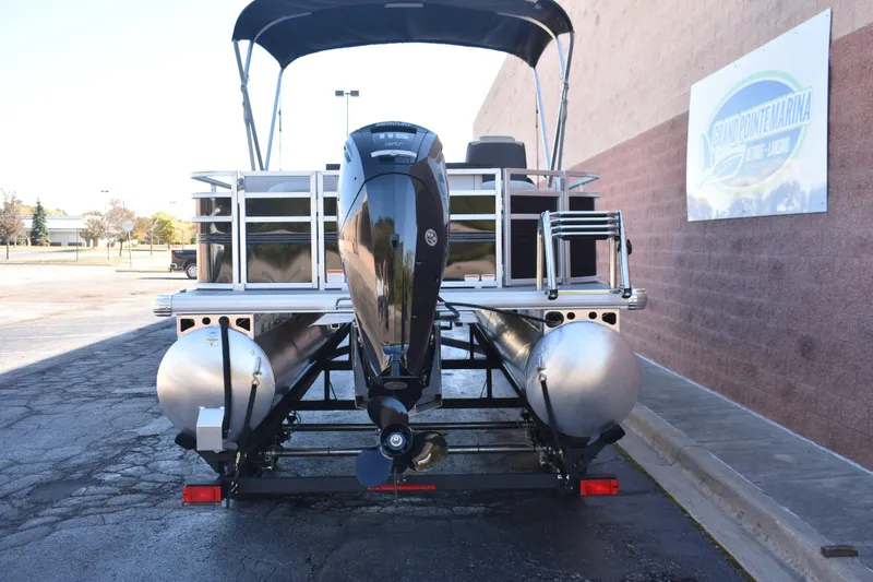 Slide: The Image of 2026 Sun Tracker Fishin' Barge 22 DLX pontoon boat with outboard motor, rear view. - 4