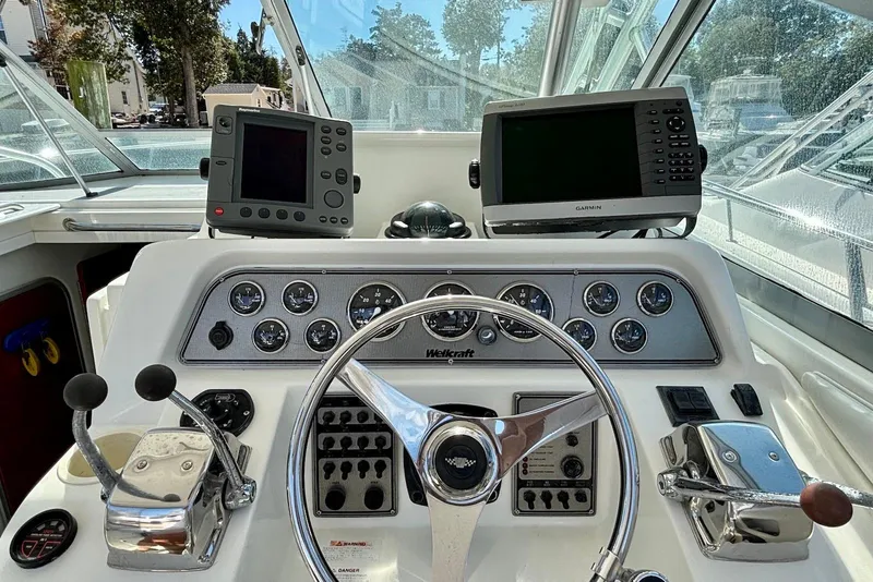 Slide: The Image of 2002 Wellcraft 330 Coastal boat dashboard with steering wheel and navigation equipment. - 4