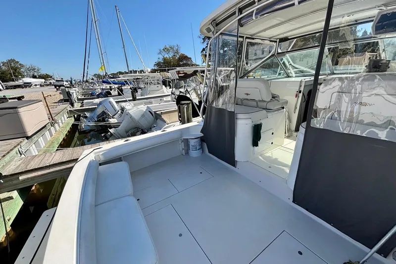 Slide: The Image of 2002 Wellcraft 330 Coastal boat docked, featuring spacious deck and seating area. - 9