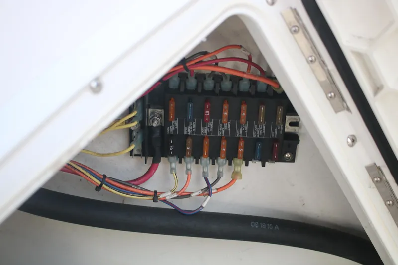 Slide: The Image of Electrical fuse panel inside 2011 Larson Carbiro 240 boat, featuring various colored wires. - 14