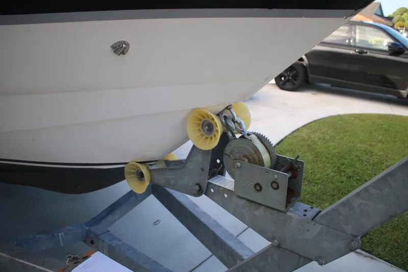 Slide: The Image of 2011 Larson Carbiro 240 boat on trailer with winch and yellow rollers. - 21