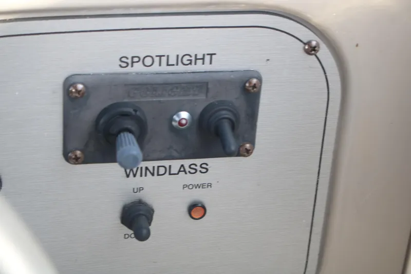 Slide: The Image of Control panel of a 2011 Larson Carbiro 240 boat featuring spotlight and windlass switches. - 25