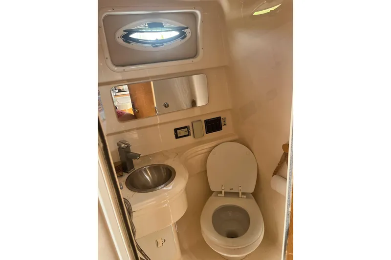 Slide: The Image of Compact bathroom in 2011 Larson Carbiro 240 boat with sink, toilet, and porthole. - 4