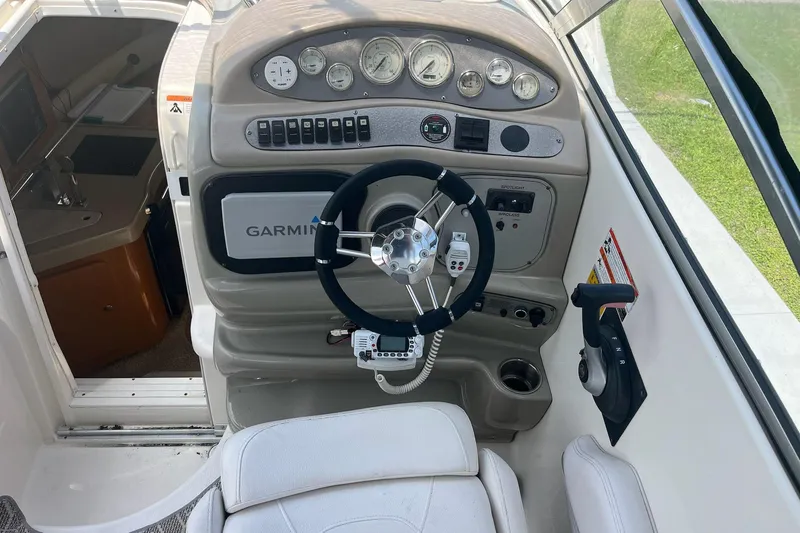 Slide: The Image of Interior cockpit of a 2011 Larson Carbiro 240 boat with steering wheel and Garmin navigation. - 5