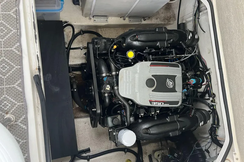 Slide: The Image of Engine compartment of a 2011 Larson Carbiro 240 boat, featuring a 350 MAG engine. - 6