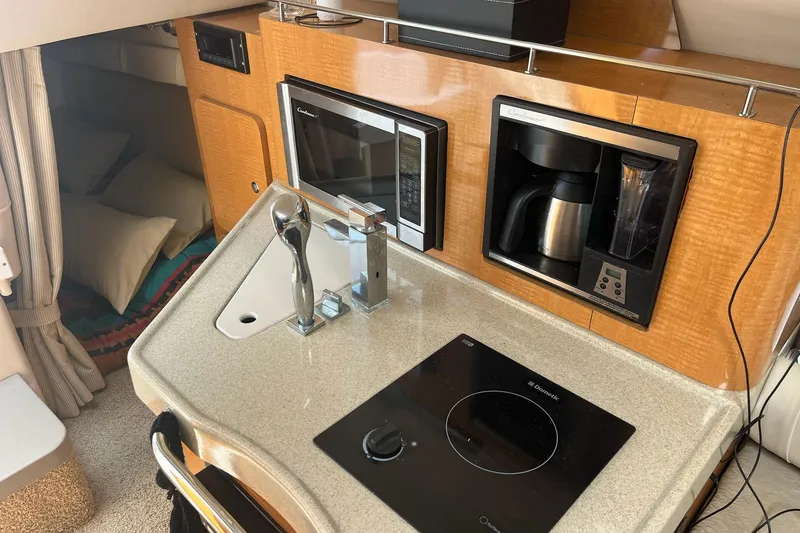 Slide: The Image of Compact kitchen area in a 2011 Larson Carbiro 240 boat with microwave and coffee maker. - 7