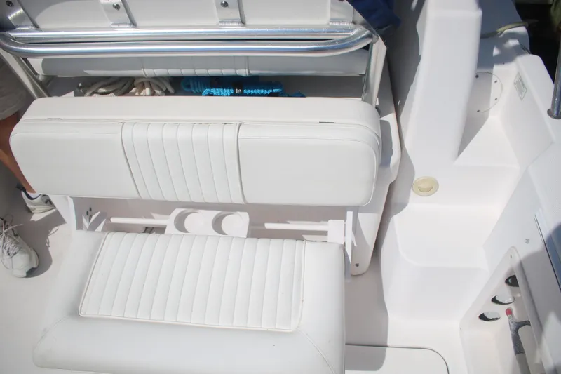 Slide: The Image of White seating area on a 2011 Larson Carbiro 240 boat, featuring storage and cup holders. - 9