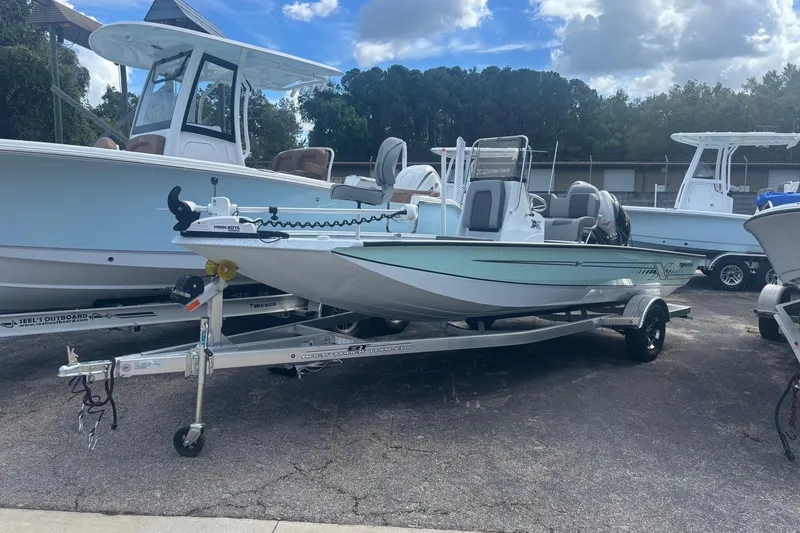 The Image of 2024 Xpress H20B Bay boat on trailer, parked outdoors under a cloudy sky. - 1