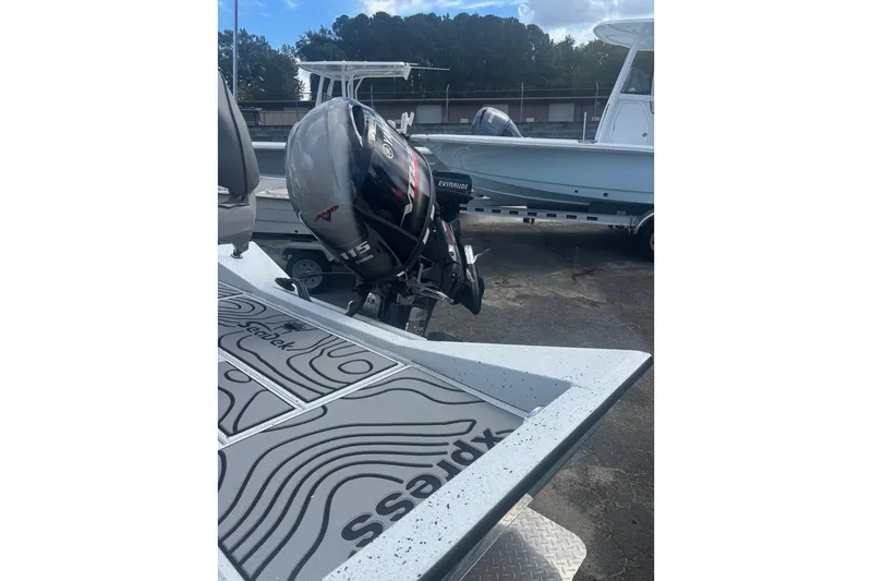 Slide: The Image of 2024 Xpress H20B Bay boat with Evinrude 115 motor, parked on a trailer. - 6