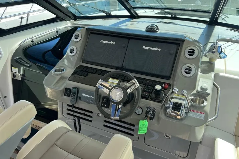 Slide: The Image of 2013 Sea Ray 540 Sundancer yacht cruising on open water near a bridge. - 11