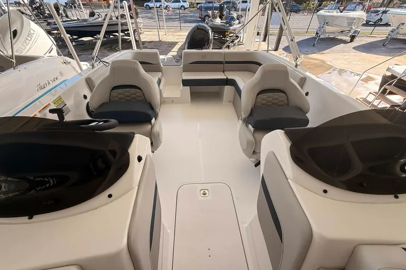 Slide: The Image of 2026 Hurricane Sundeck Sport 218 OB interior with seating and helm, docked outdoors. - 11