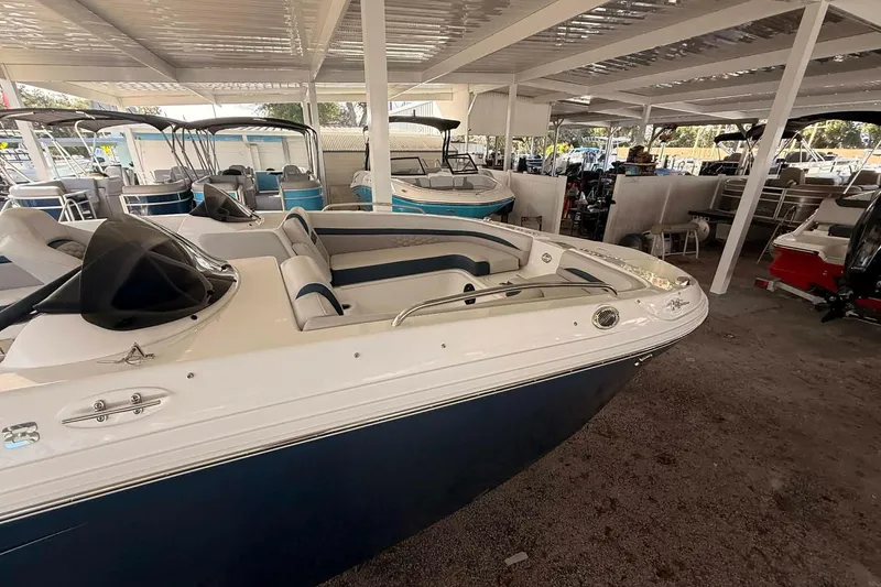 Slide: The Image of 2026 Hurricane Sundeck Sport 218 OB boat in covered storage, showcasing sleek design. - 2