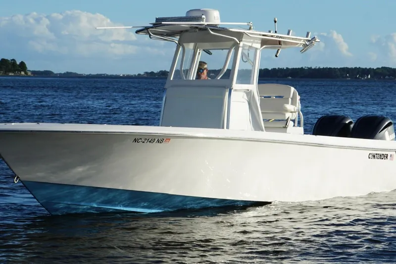 Slide: The Image of 2023 Contender 30 Tournament boat cruising on a calm lake under a clear sky. - 12